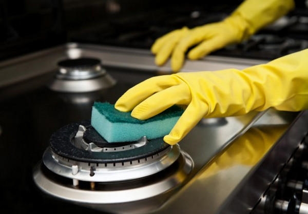 cleaning the stove with a sponge