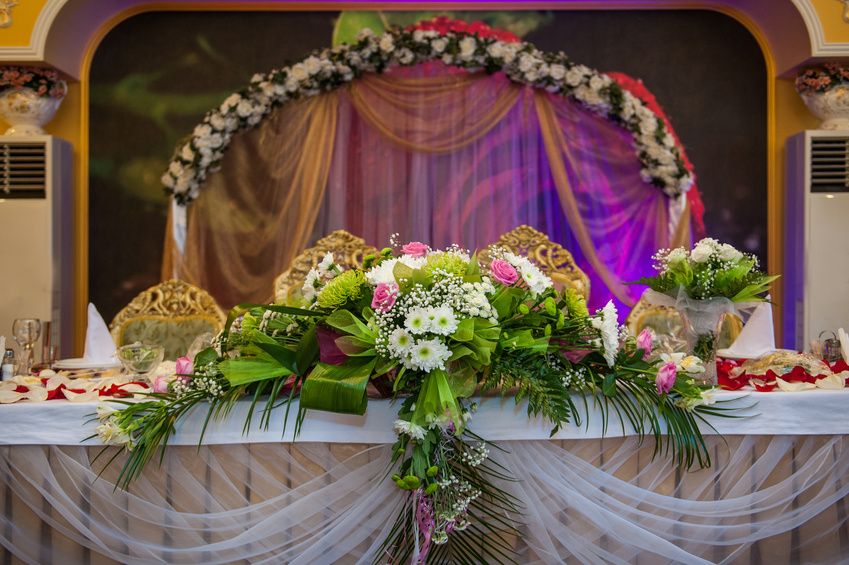 Decoración de mesa para los novios elaborada con flores frescas.