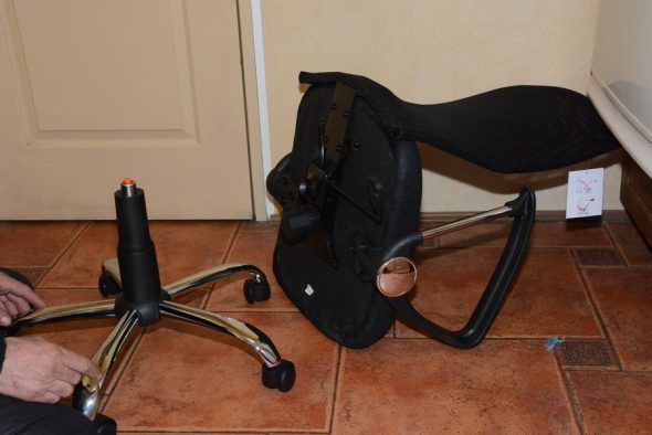 Attaching the adjusting mechanism of a computer chair to the seat.