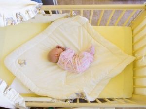 Bercer un bébé dans un berceau avec un pendule longitudinal.