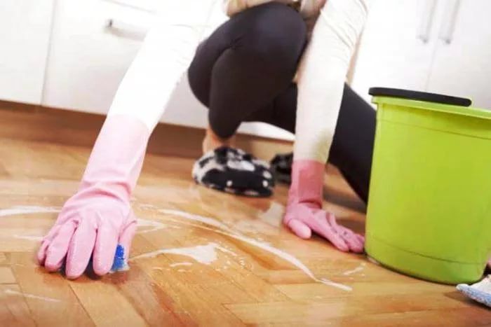 Pulizia del primer dal linoleum con una spugna abrasiva.