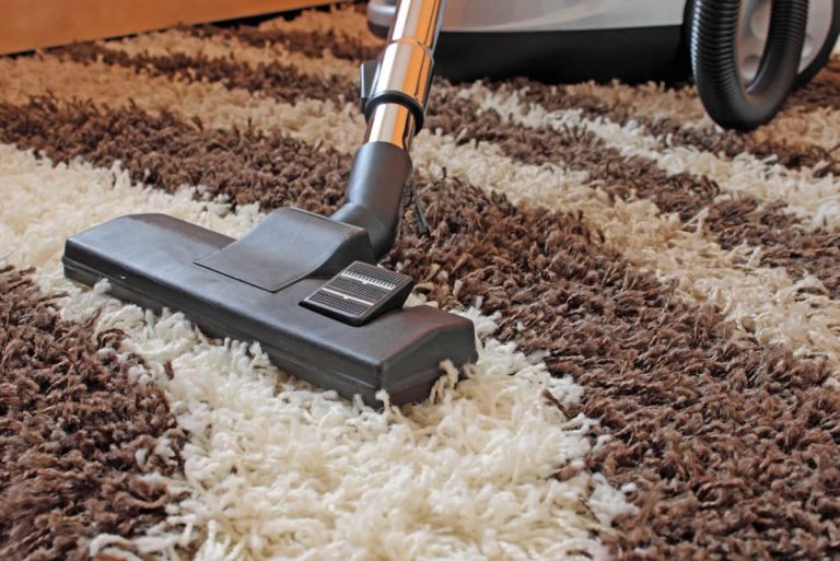 Nililinis ang mahabang pile carpet gamit ang vacuum cleaner.