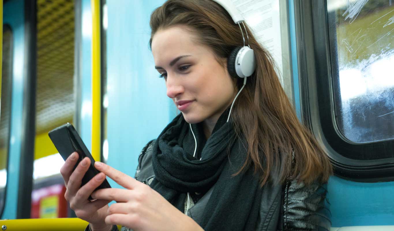 Una chica con auriculares en el transporte.