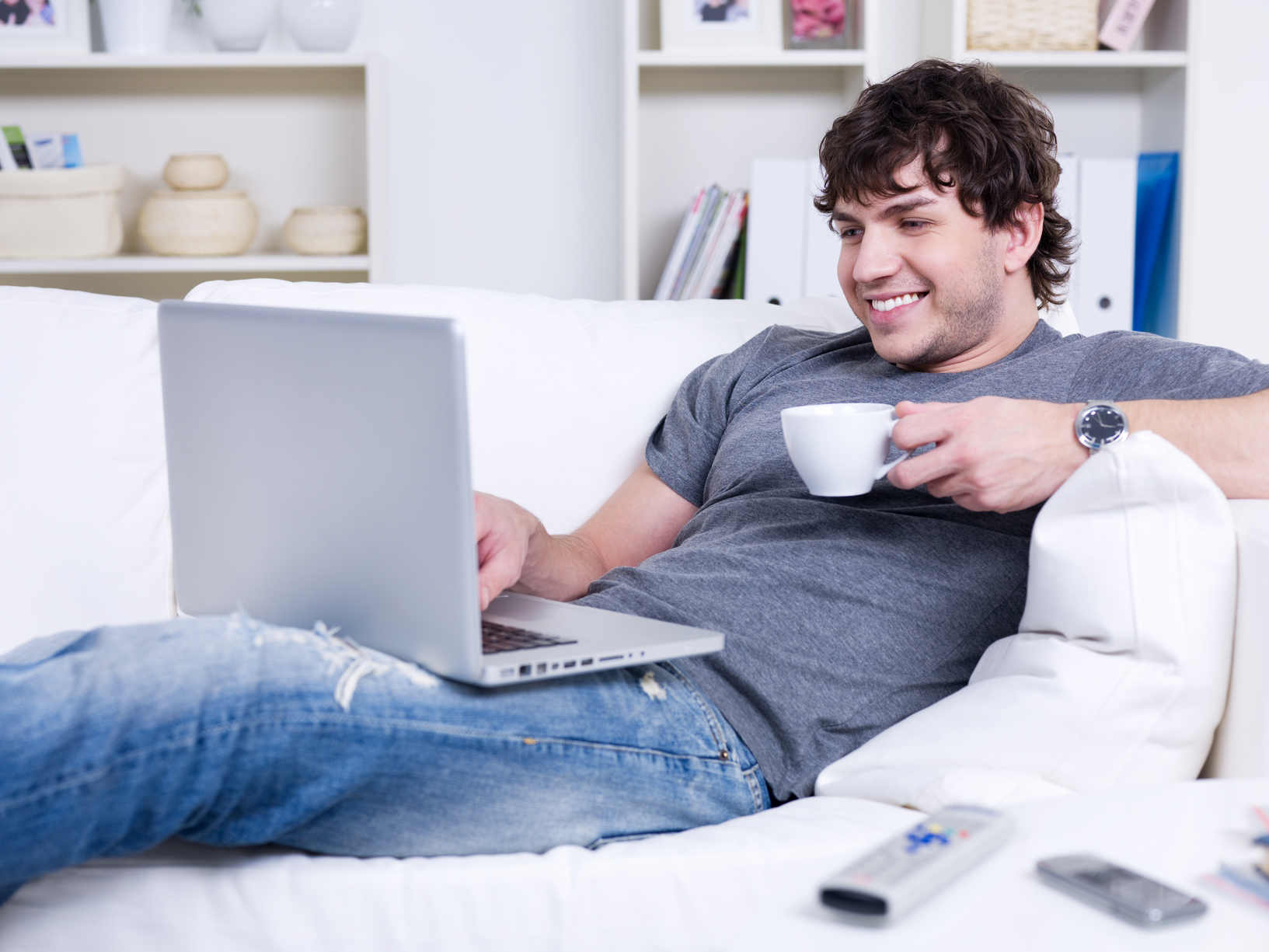 Man met laptop en kopje koffie