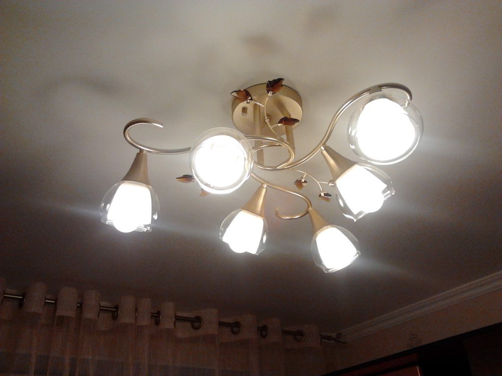 Kumikislap ang mga lamp sa chandelier.