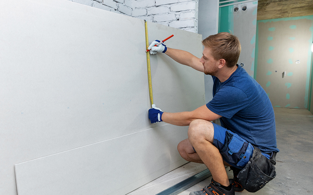 pose de plaques de plâtre sur un plafond en pente