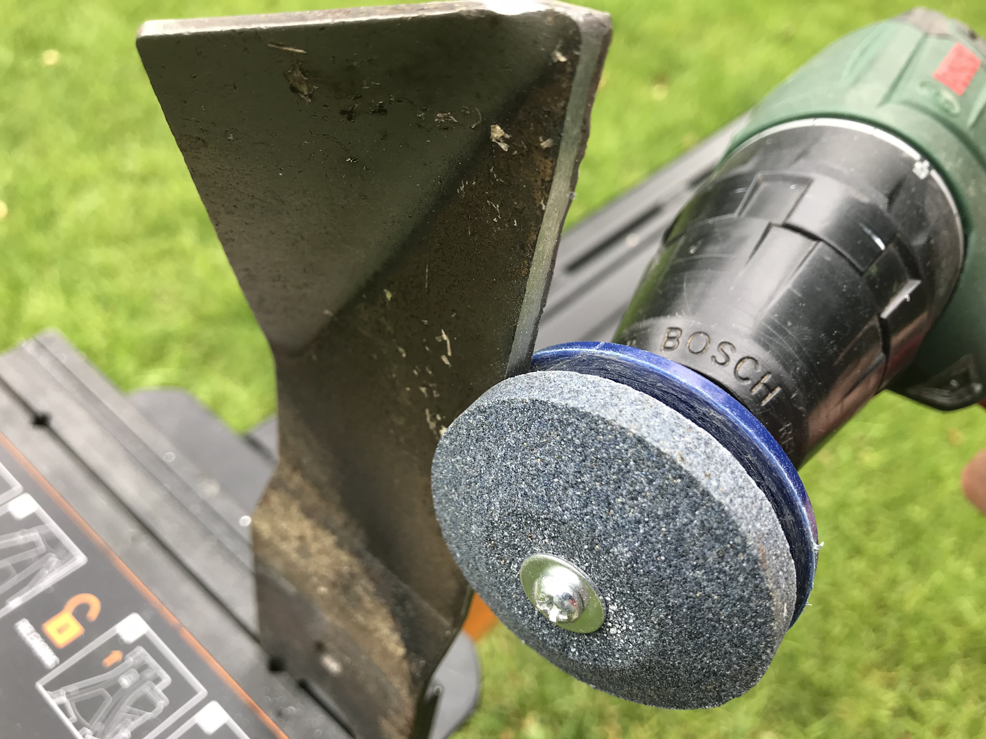 Sharpening a lawn mower blade using a drill.