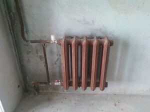 Mengikat radiator besi tuang ke dinding